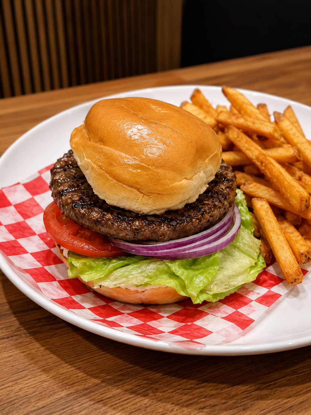 Cheeseburger and fries served on a white plate